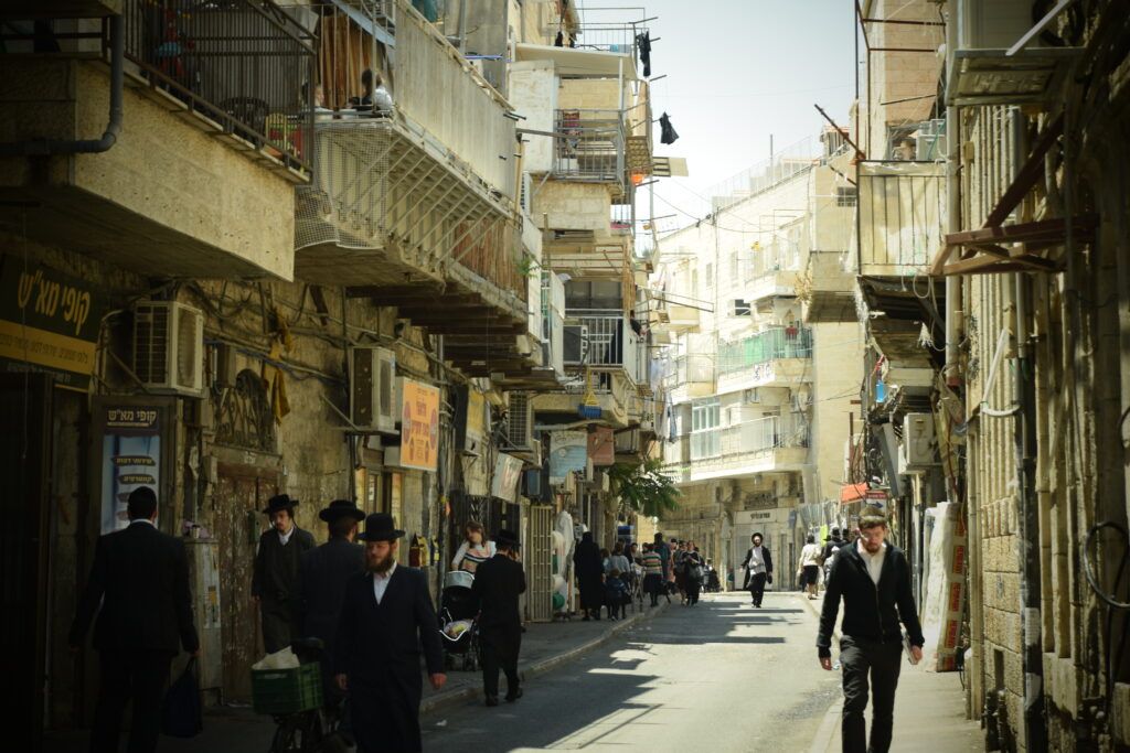 ultra-orthodox jewish people walking on the street of mea shearim area in jerusalem.